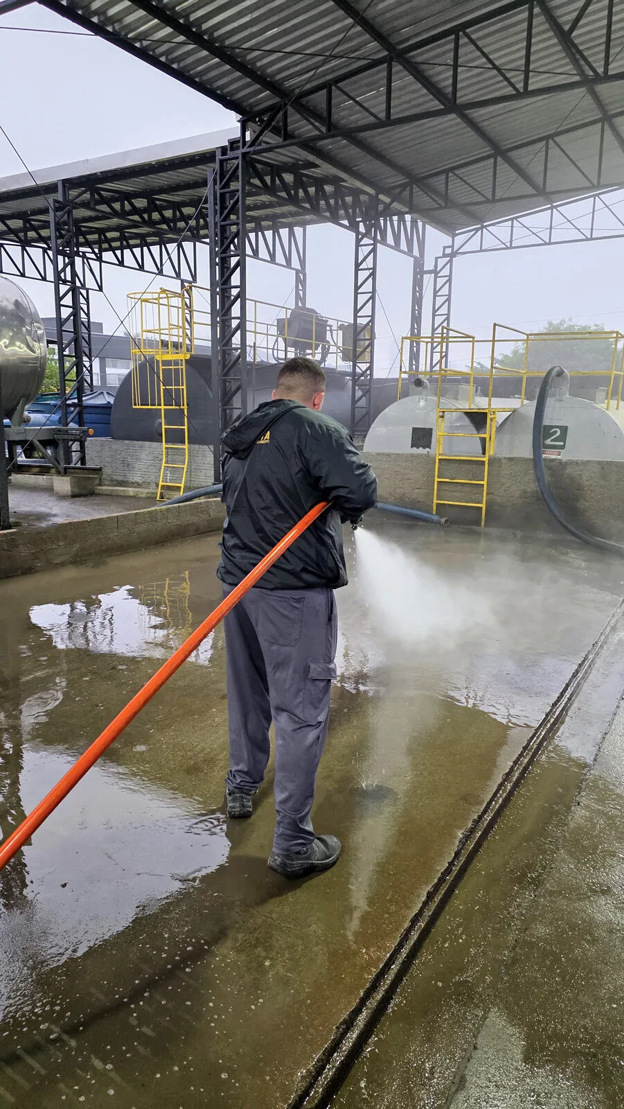 Técnico lavando um pátio com hidrojateamento de alta pressão